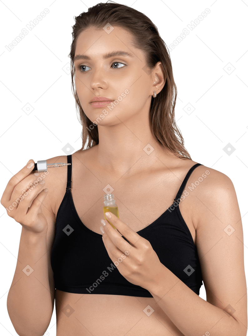 Front view of a young woman using face serum