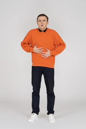 Young man in orange sweatshirt standing