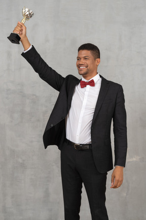 Man holding up award in celebration of his win