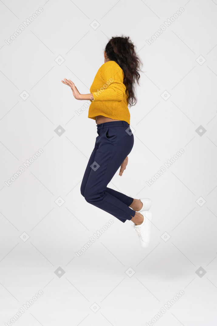 ジャンプして足に触れるカジュアルな服装の女の子の側面図