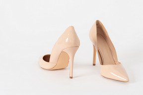 A shot of a pair of beige lacquered stiletto shoes