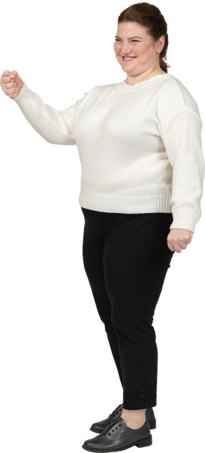 Felice plus size donna in maglione bianco in posa