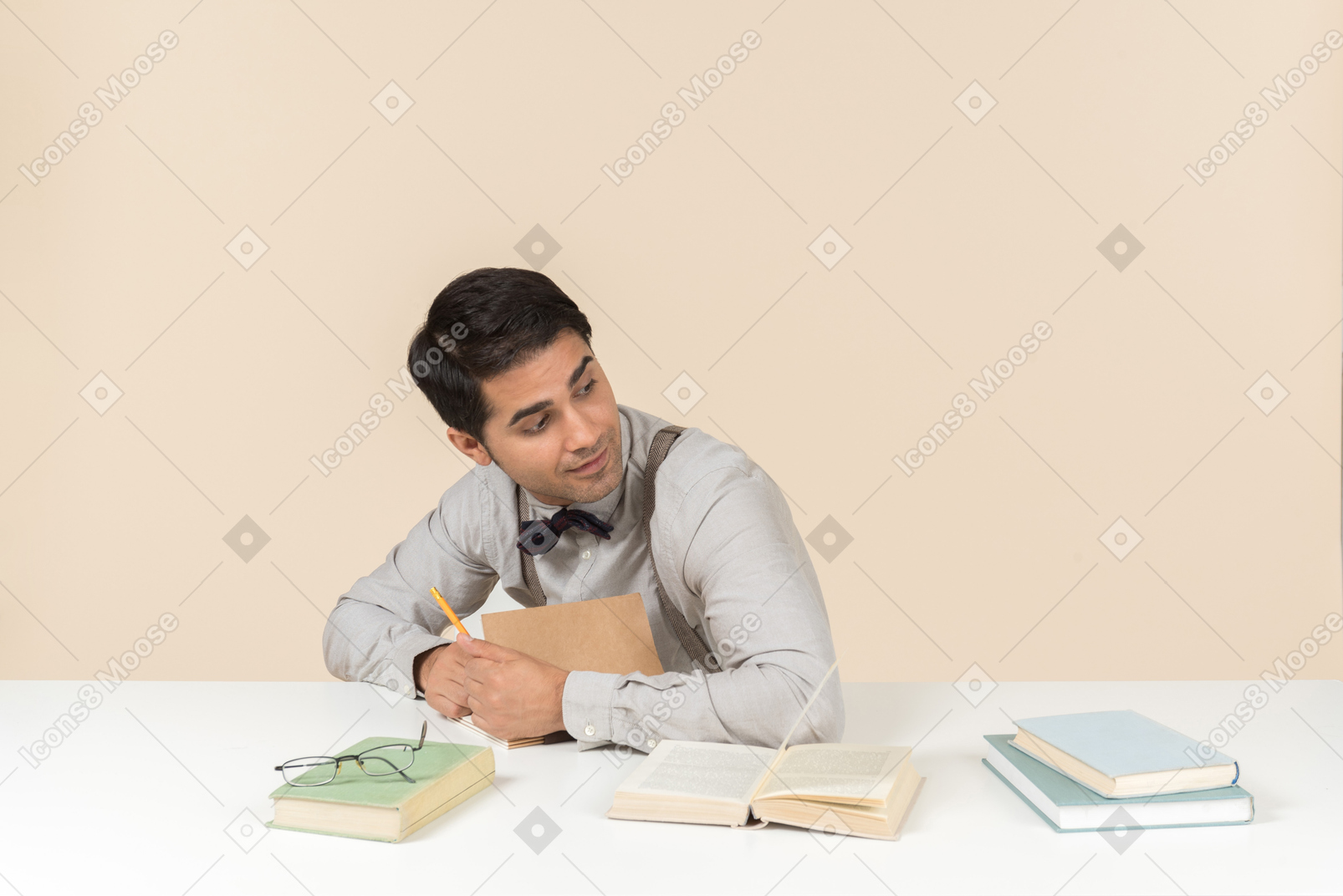 テーブルに座って、本に何かを書く若い大人の学生
