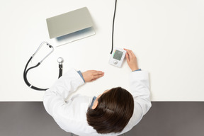 A female doctor looking at a sphygmomanometer