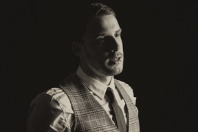 Portrait of a handsome man from 20s isolated over black background