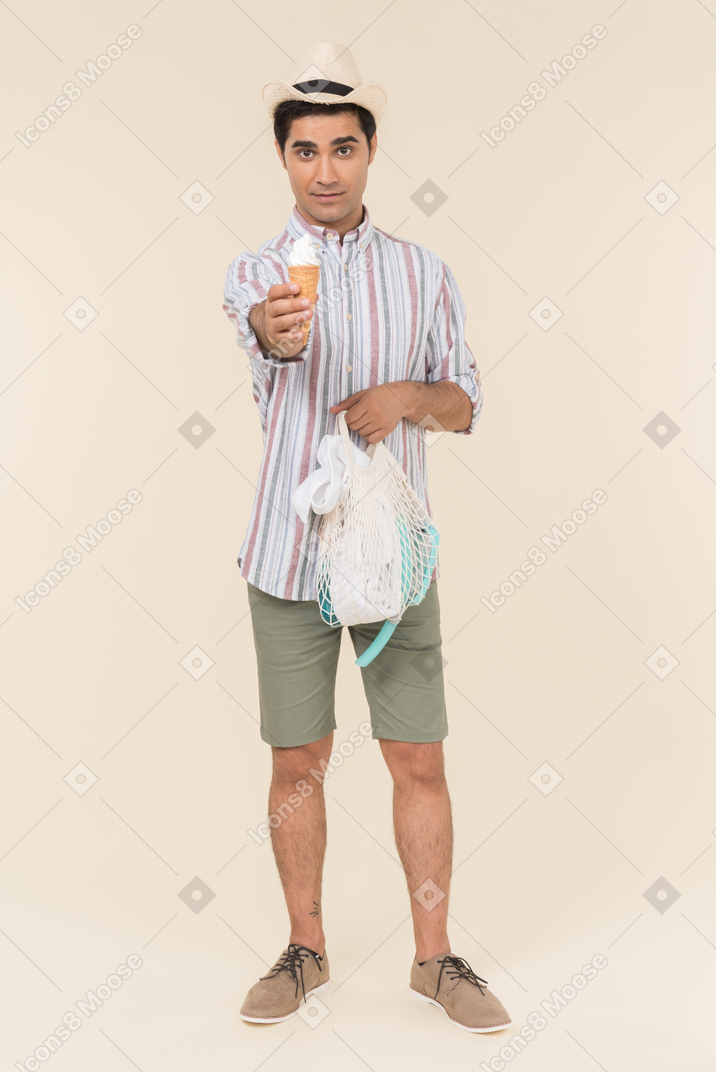 Young caucasian guy holding avoska and ice cream and offering it