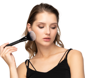 Front view of a sensual young woman holding a make-up brush