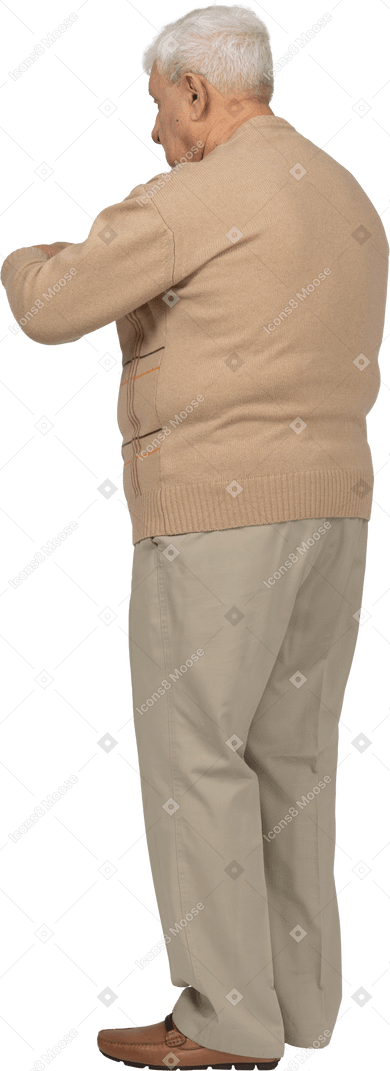 Vista lateral de um velho em roupas casuais, apontando com o dedo