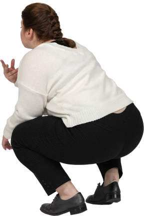 Вид сзади на корточки пухлой женщины в повседневной одежде