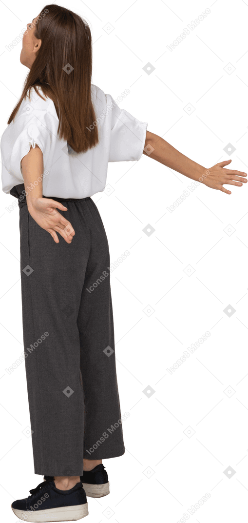 Vista posteriore di tre quarti di una giovane donna in abiti da ufficio che allarga le braccia