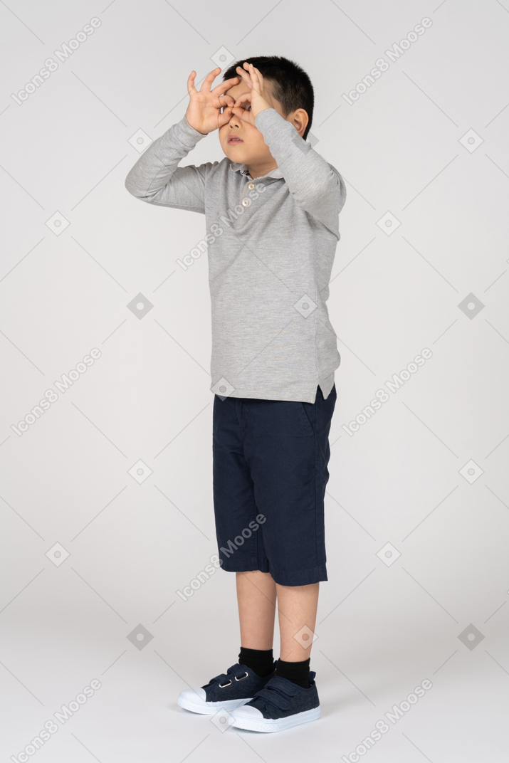 Garçon faisant des lunettes avec ses mains