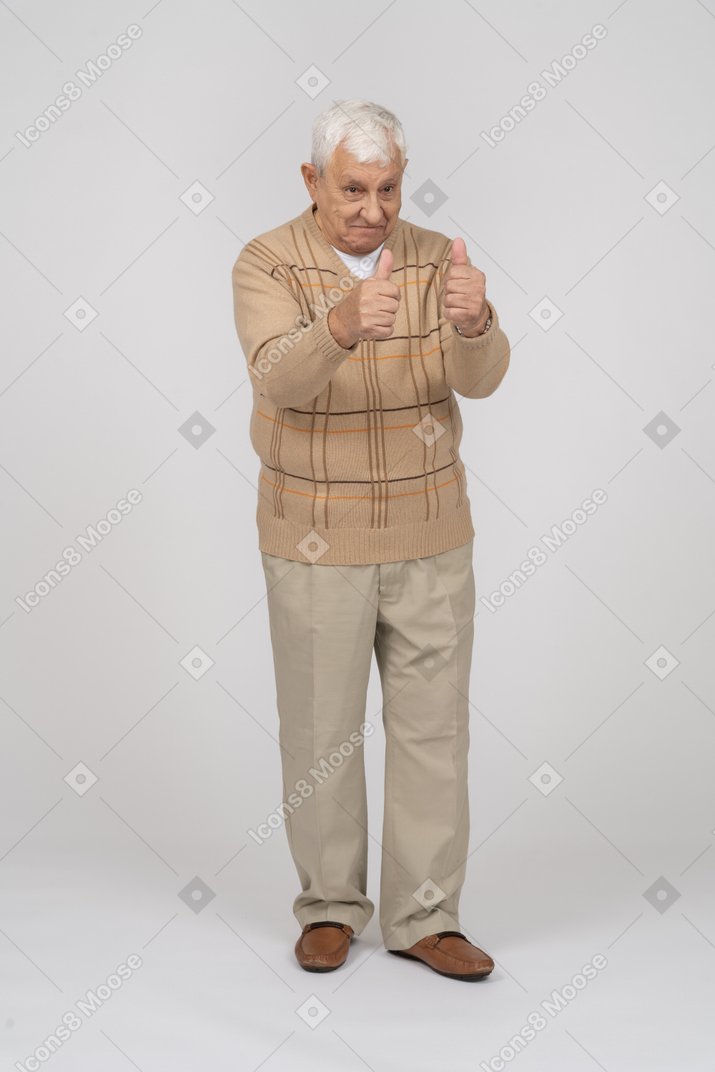 Front view of a happy old man in casual clothes showing thumbs up