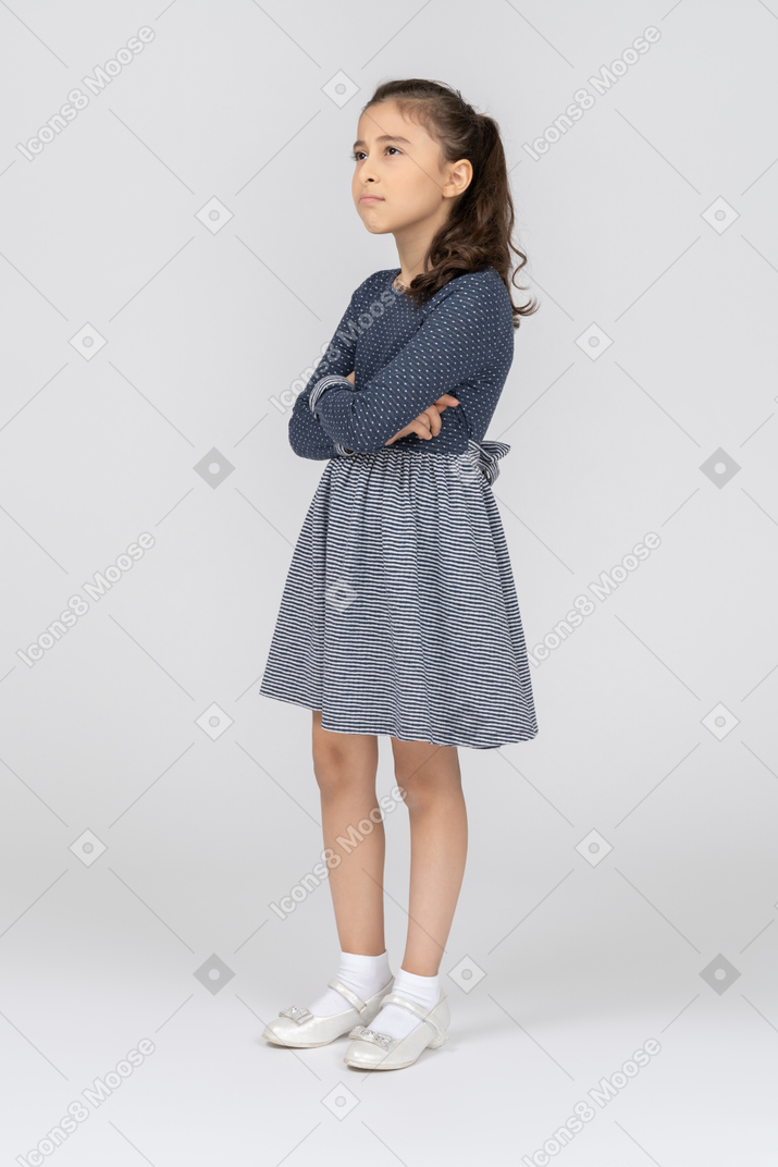 Three-quarter view of a girl pouting thoughtfully with folded hands