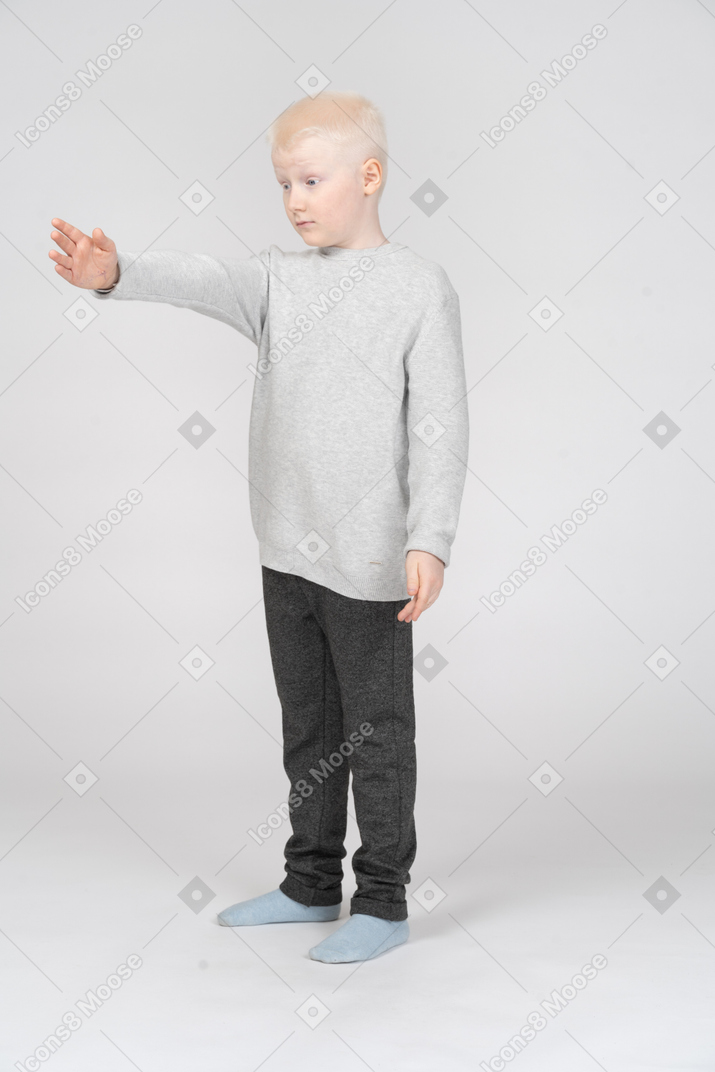 Little boy standing with his arm outstretched