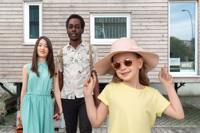 Interracial family standing outside and kid girl looking stylish