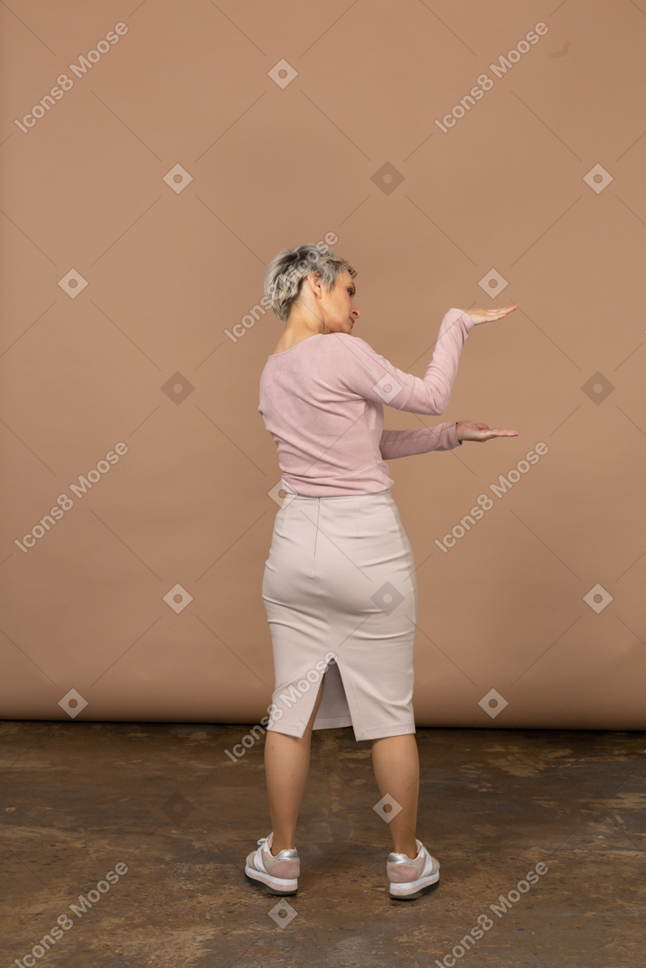 Retrovisor de uma mulher com roupas casuais mostrando o tamanho de algo