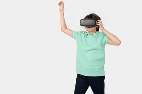 Garoto com fone de ouvido vr segurando algo invisível