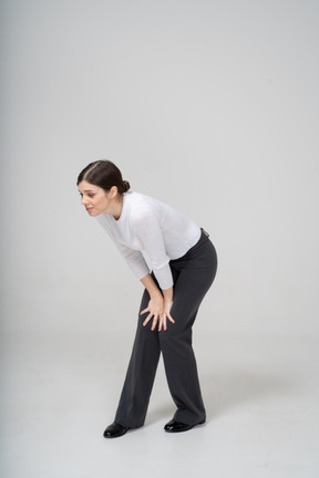 Front view of a woman in suit bending down