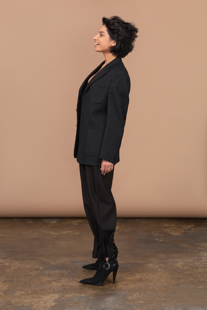 Side view of a surprised smiling businesswoman wearing black suit