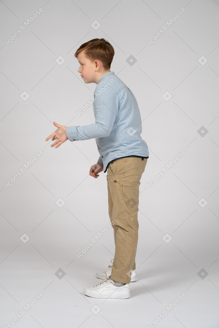 Young boy in blue shirt and khaki pants gesturing