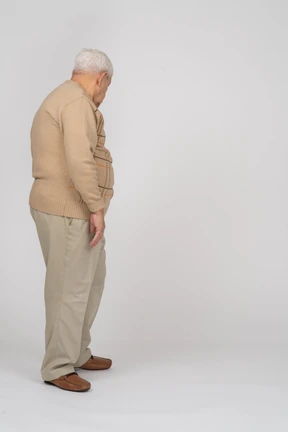 Side view of an old man in casual clothes looking down