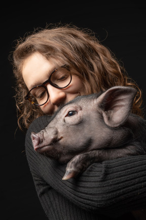 Hermosa chica con cerdo en miniatura