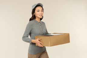 Young asian delivery girl holding boxes with folder on it