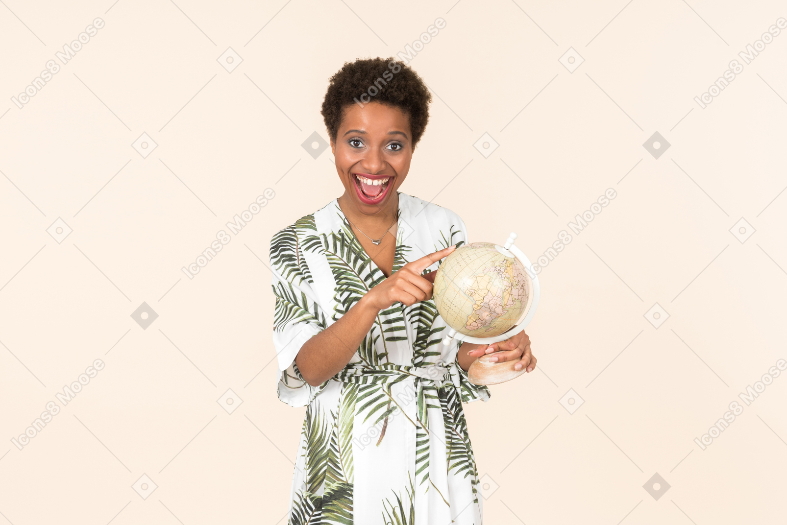 Schwarze kurzhaarige frau in einem weißen und grünen kleid, stehend mit einem globus in der hand