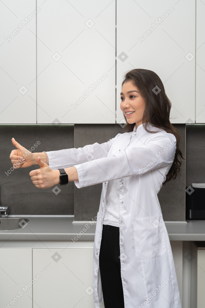 A smiling female nurse showing like gesture with both her hands