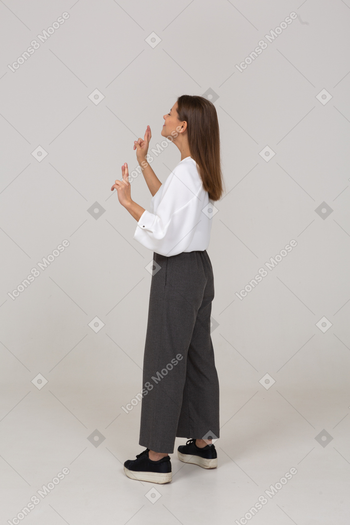 Side view of a young lady in office clothing crossing fingers