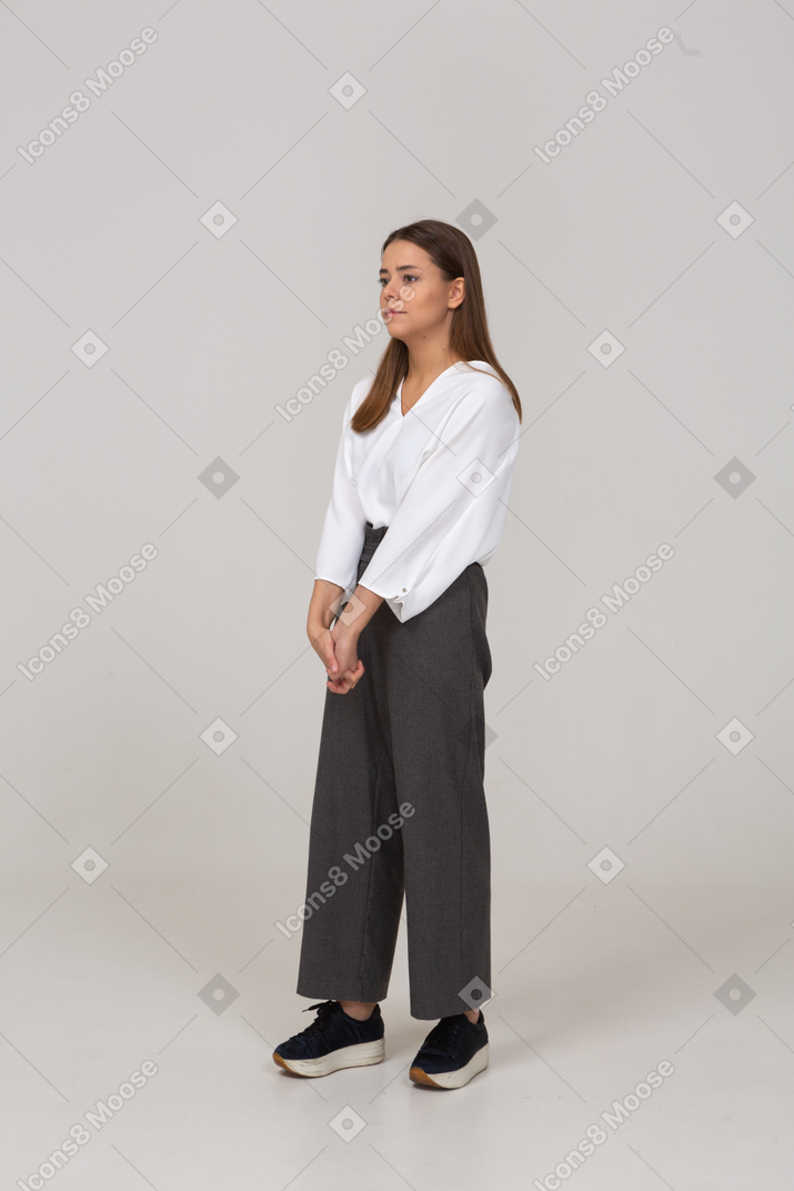 Вид в три четверти молодой леди в офисной одежде, держащейся за руки