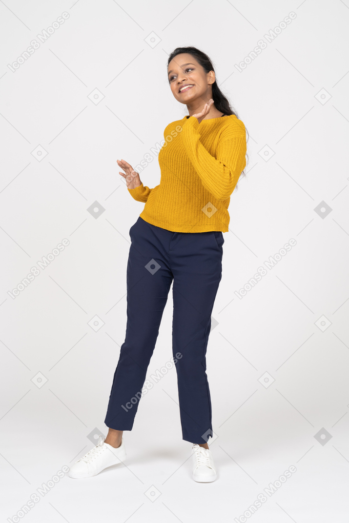 Front view of a happy girl in casual clothes waving