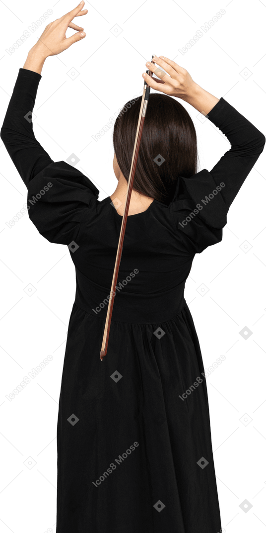 Вид сзади молодой леди в черном платье, держащей лук за спиной