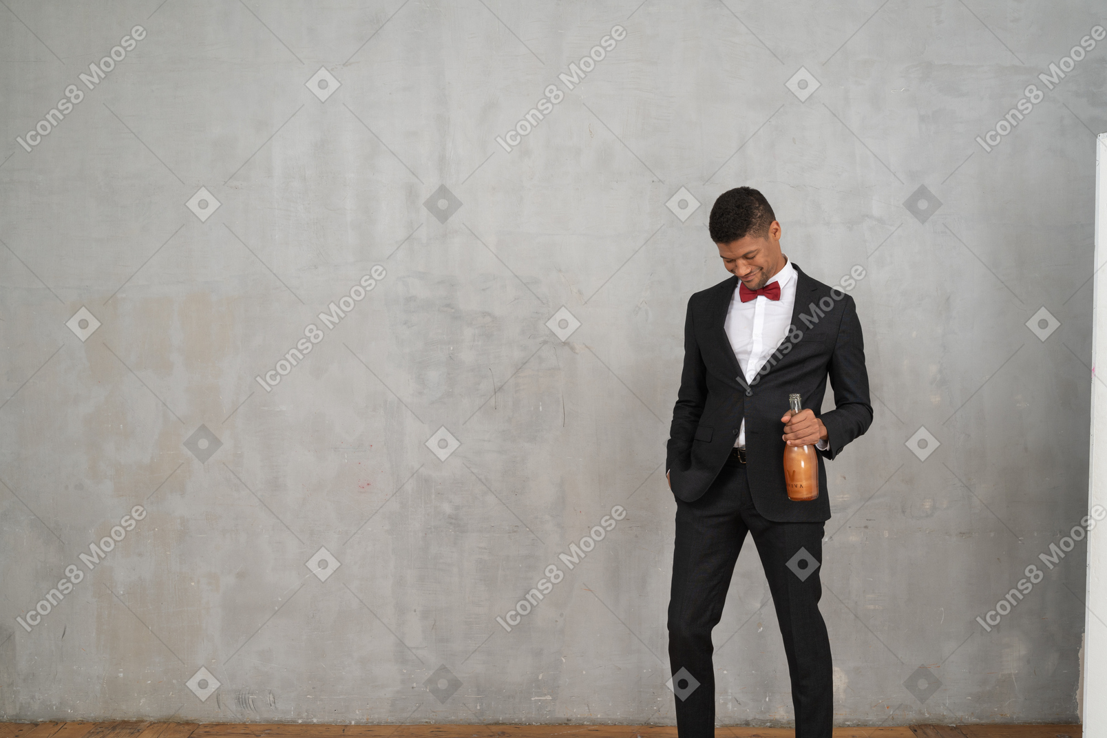 Uomo sorridente con una bottiglia di champagne che guarda in basso
