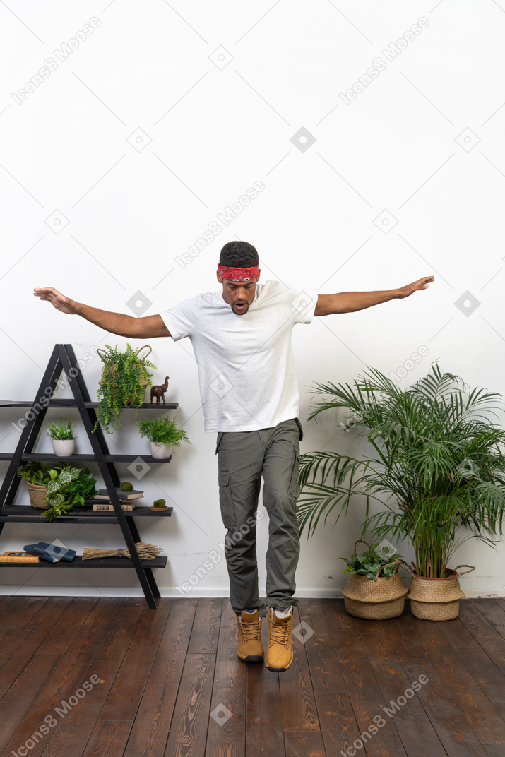 Good looking young man posing on the background of the apartment
