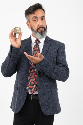 Hombre maduro sosteniendo una moneda de monero