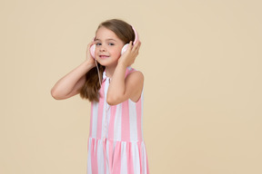 Cute little girl in the headphones listening to a music