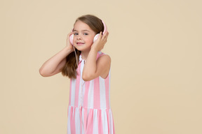 Mignonne petite fille au casque écoutant de la musique