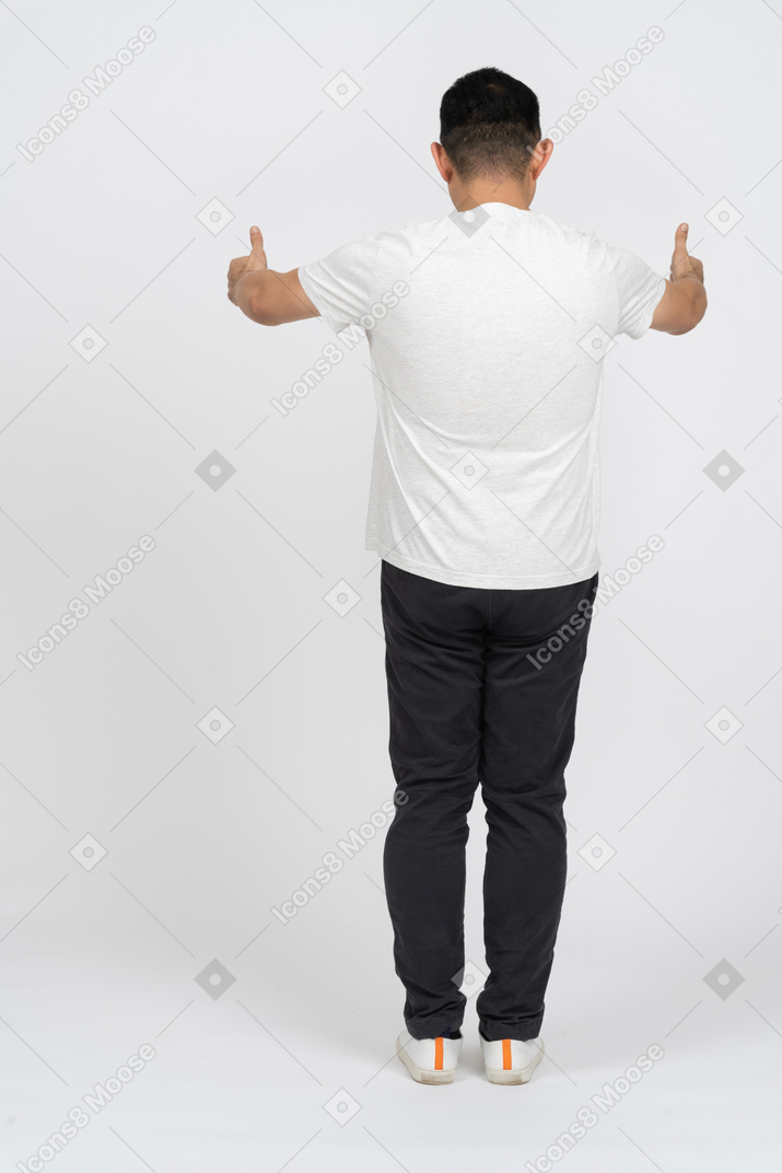 Rear view of a man in casual clothes showing thumbs up