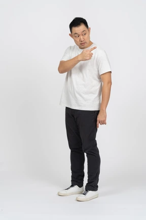 Three-quarter view of a man in casual clothes making warning gesture