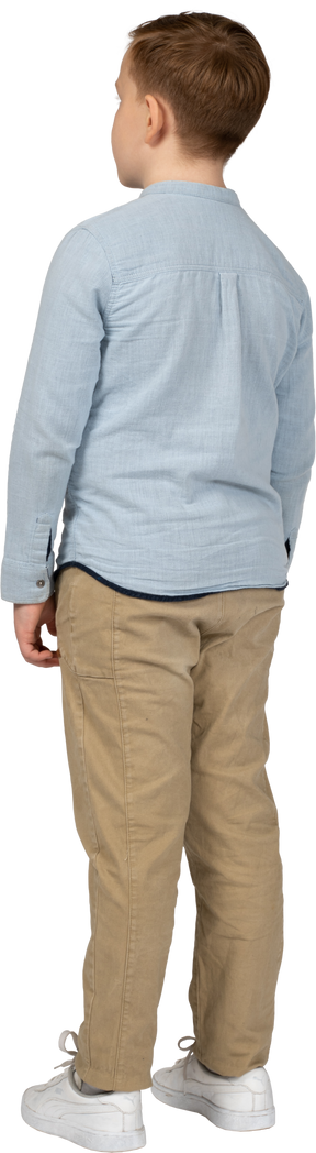 Rear view of a boy in casual clothes standing still