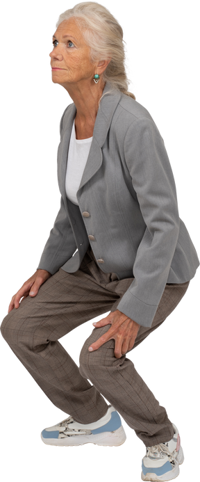 Vista lateral de una anciana en traje en cuclillas