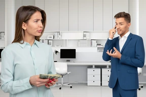 A man in a blue suit talking on a cell phone next to a woman with dollar bills