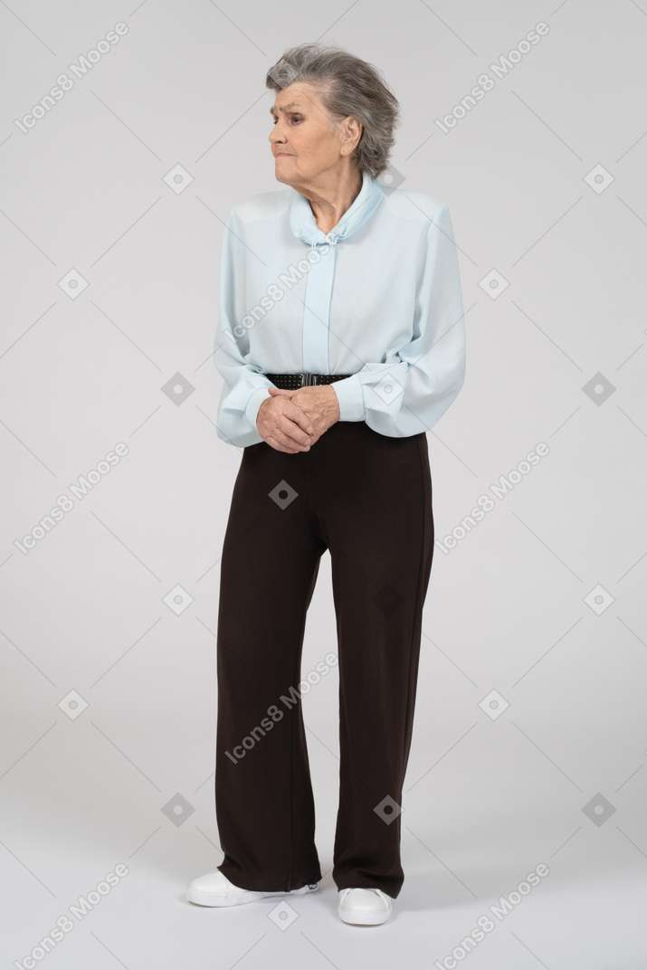 Вид спереди на пожилую женщину, поджимающую губы сложенными руками