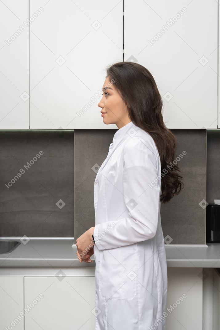 Side shot of a young female nurse standing still