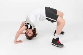 Ahtletic kid boy is doing  a backbend