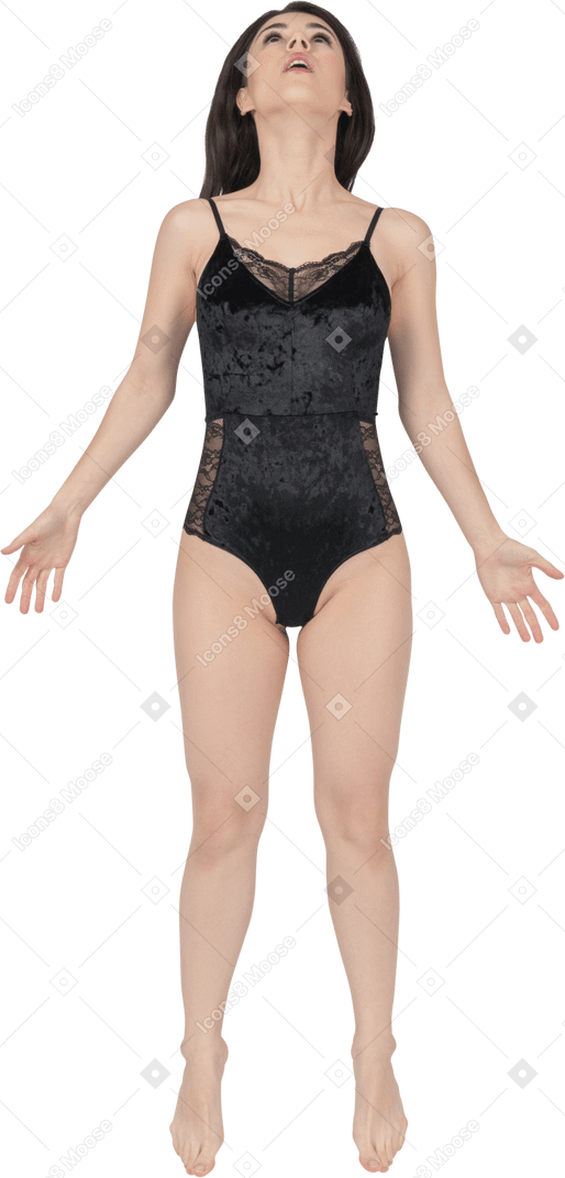 Jeune femme en body de velours noir sautant avec les mains écartées