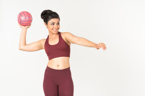 Giovane donna indiana in abiti sportivi sta per lanciare una palla
