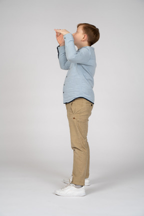 A little boy standing in front of a white background