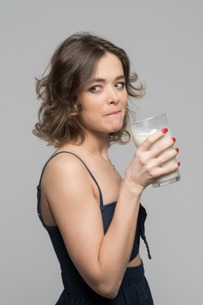 Mujer bonita sosteniendo un vaso de leche